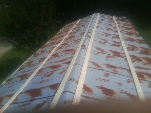 Rusted metal roof panels with new wood purlins before replacement — Storm Damage Roof Repair in Parker by Roofing Brothers